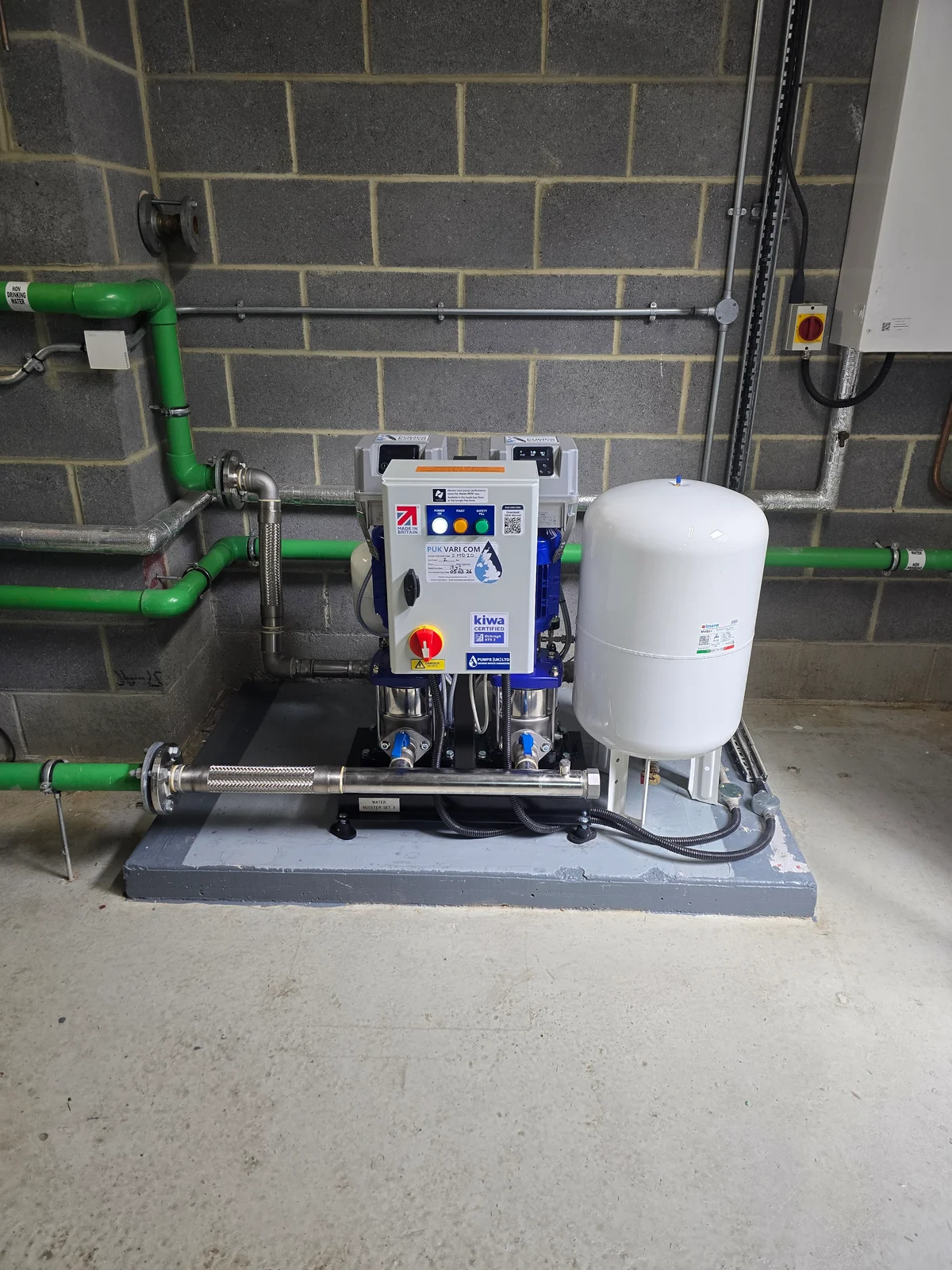 Water booster set with control panel, pressure vessel and connected pipework