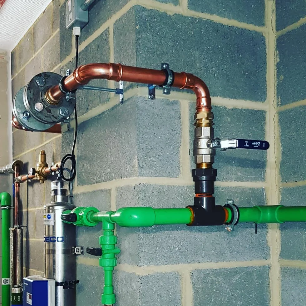 Close-up of the flanged copper pipe connection and isolation valve